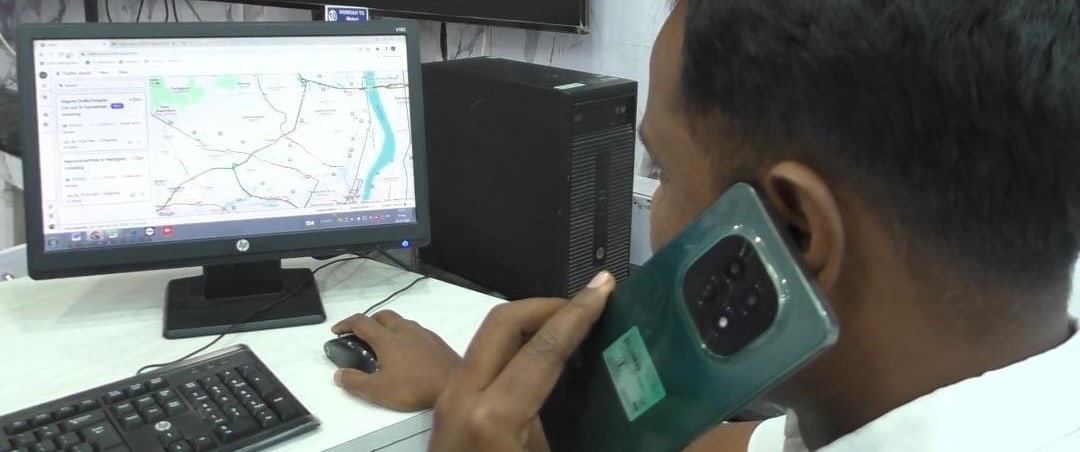 An operator in the Pune traffic control room acting on a TraffiCure alert, the live road map on screen beside him